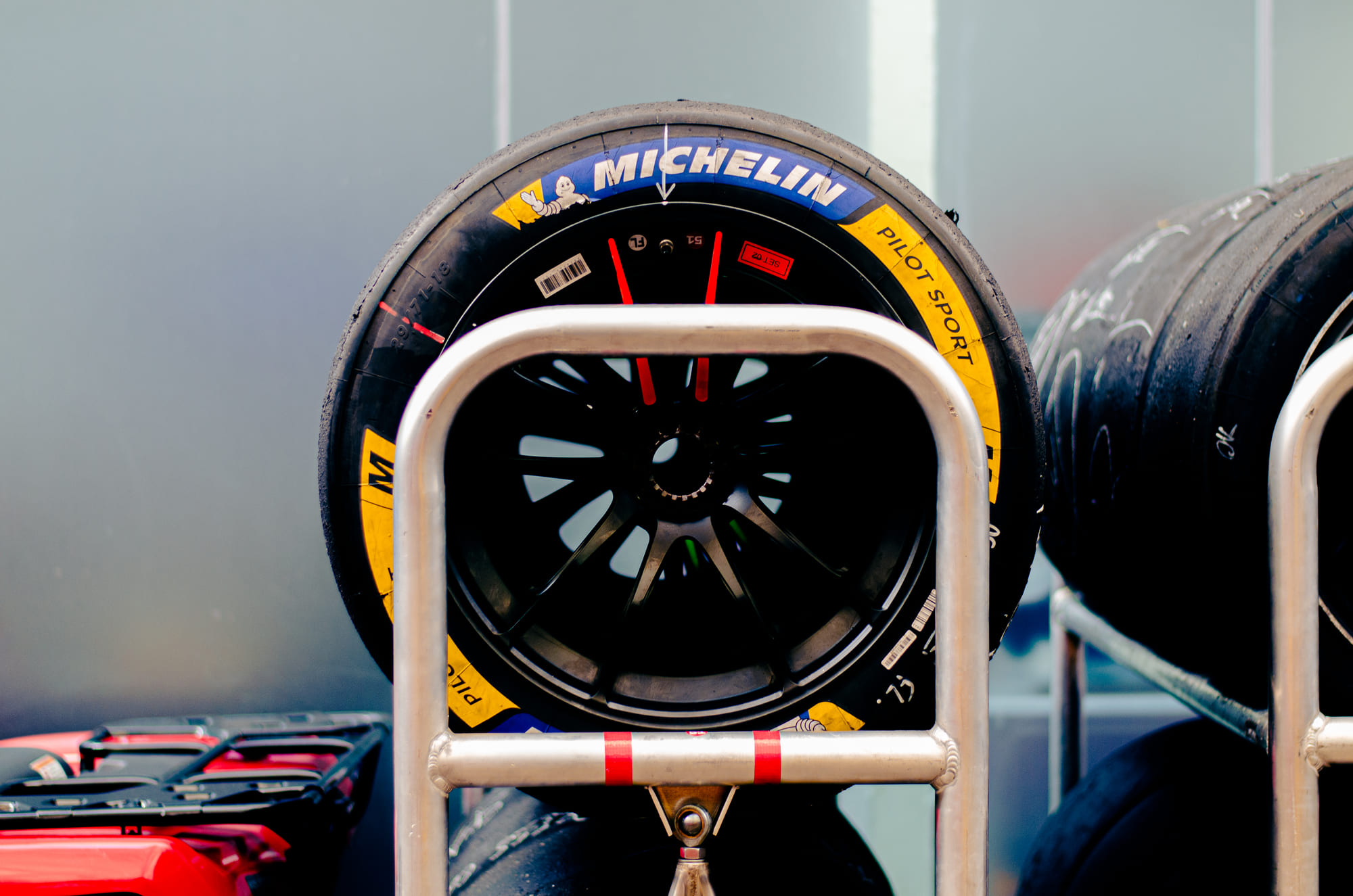 Pneu slick Michelin Pilot Sport montado no carrinho, com mais jogos atrás nos boxes, no paddock do WEC 6 Horas de São Paulo 2026, em Interlagos