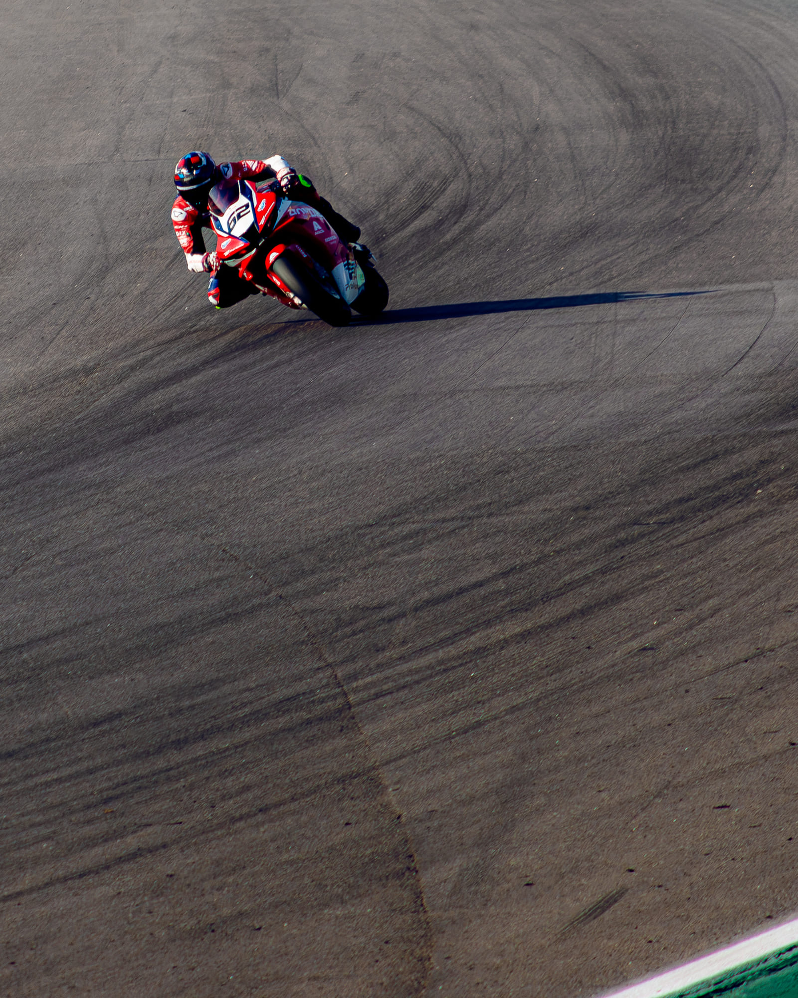Honda #62 vermelha da Honda Racing, da classe GP1000, inclinada na curva com Kevin Fontainha, sombra longa sobre o asfalto marcado, no Moto1000GP 2026 - Etapa 5, Interlagos