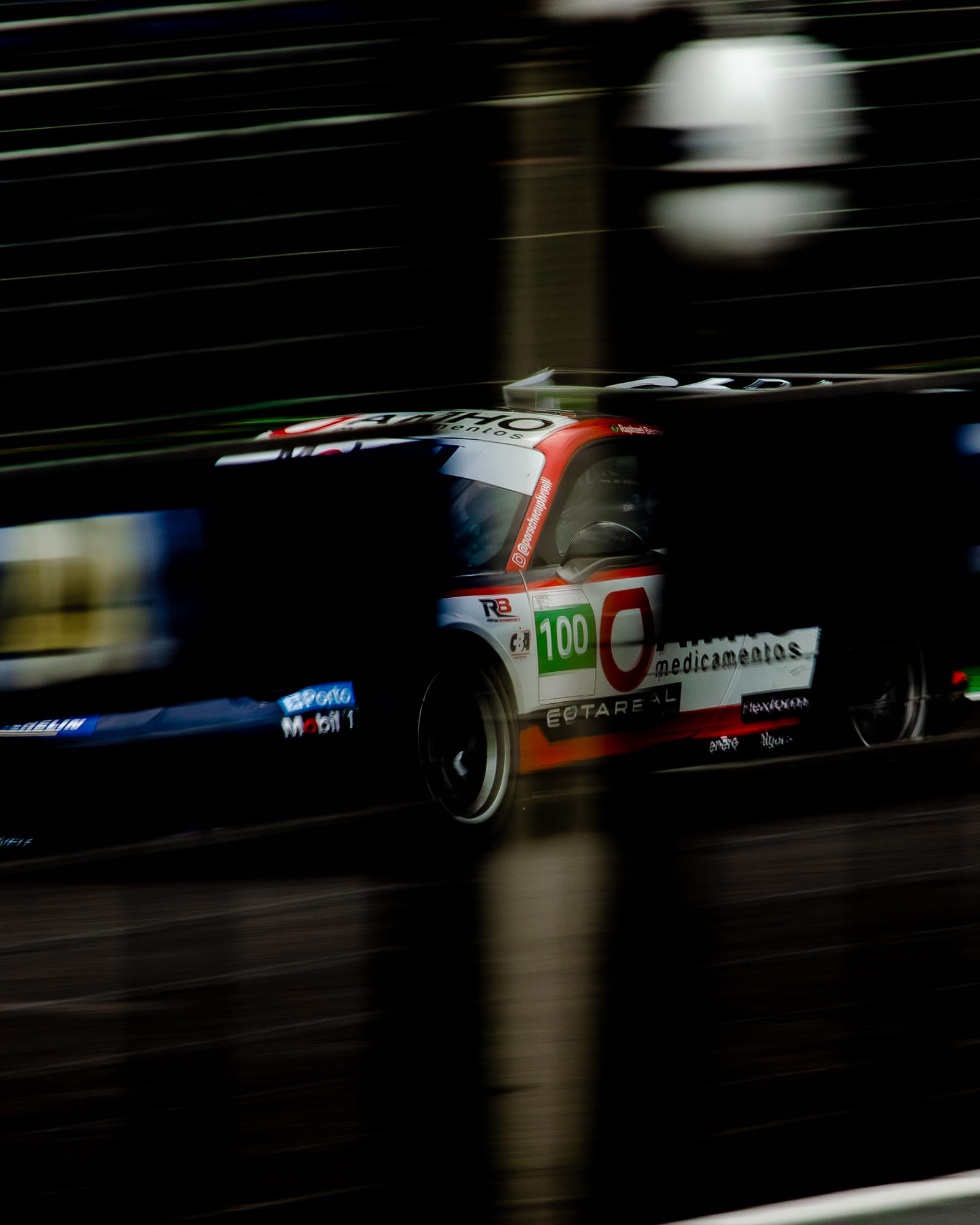 Porsche Cup #100 varrendo o muro dos boxes, tudo desfocado pela velocidade — Rapha Bernardes, Challenge Rookie, Porsche Cup Brasil 2026 - Etapa 7, Interlagos