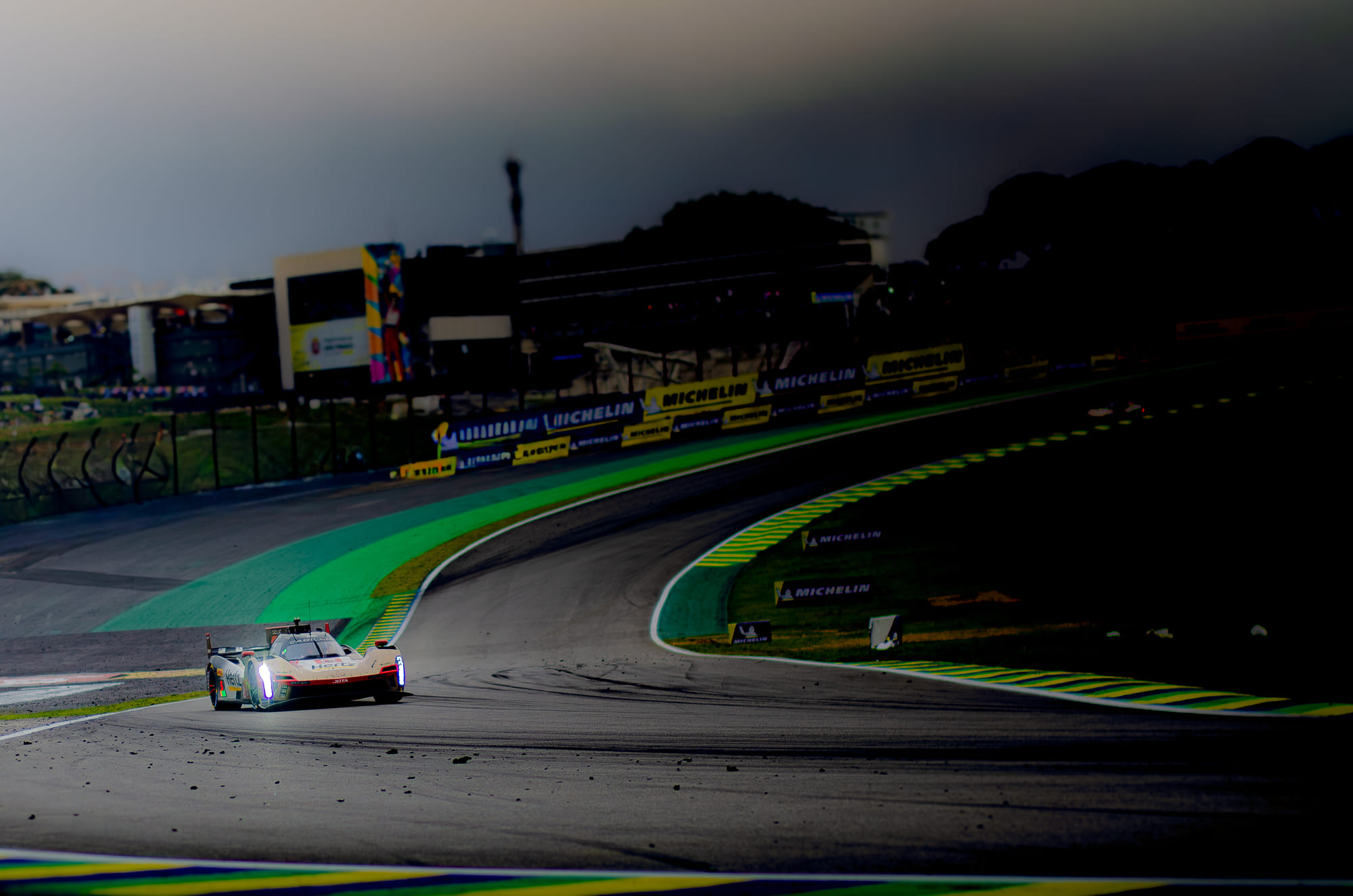 Cadillac V-Series.R #12 da Cadillac Hertz Team Jota, da classe Hypercar, de faróis acesos contornando a curva entre detritos e sombra, com Alex Lynn, Will Stevens e Norman Nato, no WEC 6 Horas de São Paulo 2026, em Interlagos
